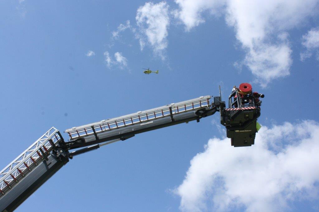 Yorkshire Air Ambulance flies over the West Yorkshire Fire Service Aerial appliance.